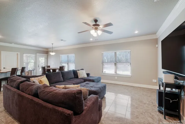 a living room with furniture a ceiling fan and a window