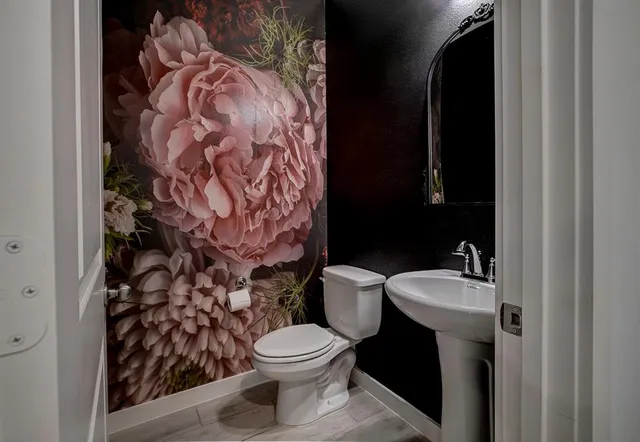 a spacious bedroom with a bed and a flat tv screen on dresser