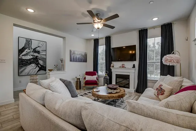 a living room with furniture a fireplace and a flat screen tv