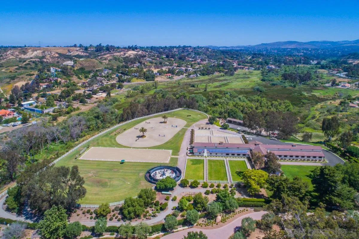 an aerial view of residential houses with outdoor space and trees