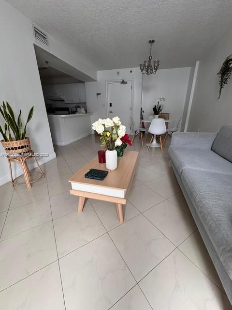 104 Southwest 9th Street, Unit 1403 Miami, FL 33130 - Photo 2 of 11 a living room with furniture a chandelier and a dining table
