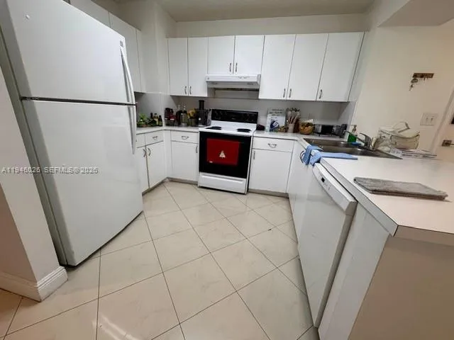 a kitchen with a refrigerator sink stove and cabinets