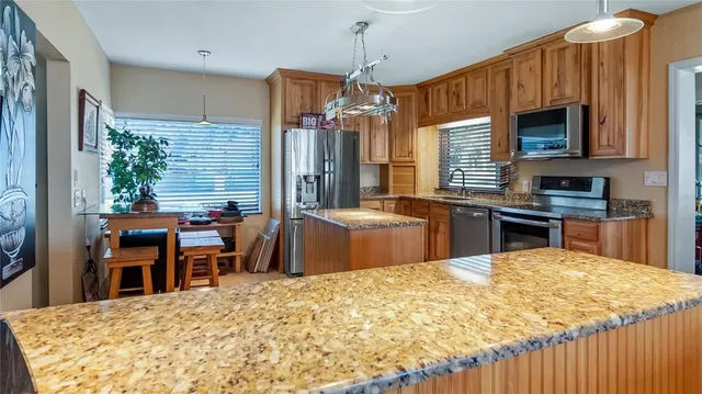 a kitchen with stainless steel appliances granite countertop a refrigerator stove and sink