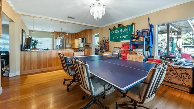 a view of a dining room with furniture a chandelier and wooden floor