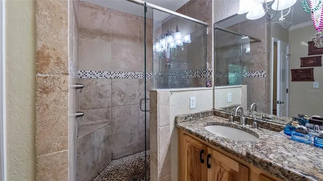 a bathroom with a granite countertop sink a mirror and shower