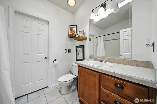 a spacious bathroom with a sink a toilet and a mirror