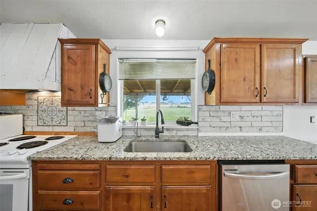 a kitchen with granite countertop a sink and a wooden cabinets