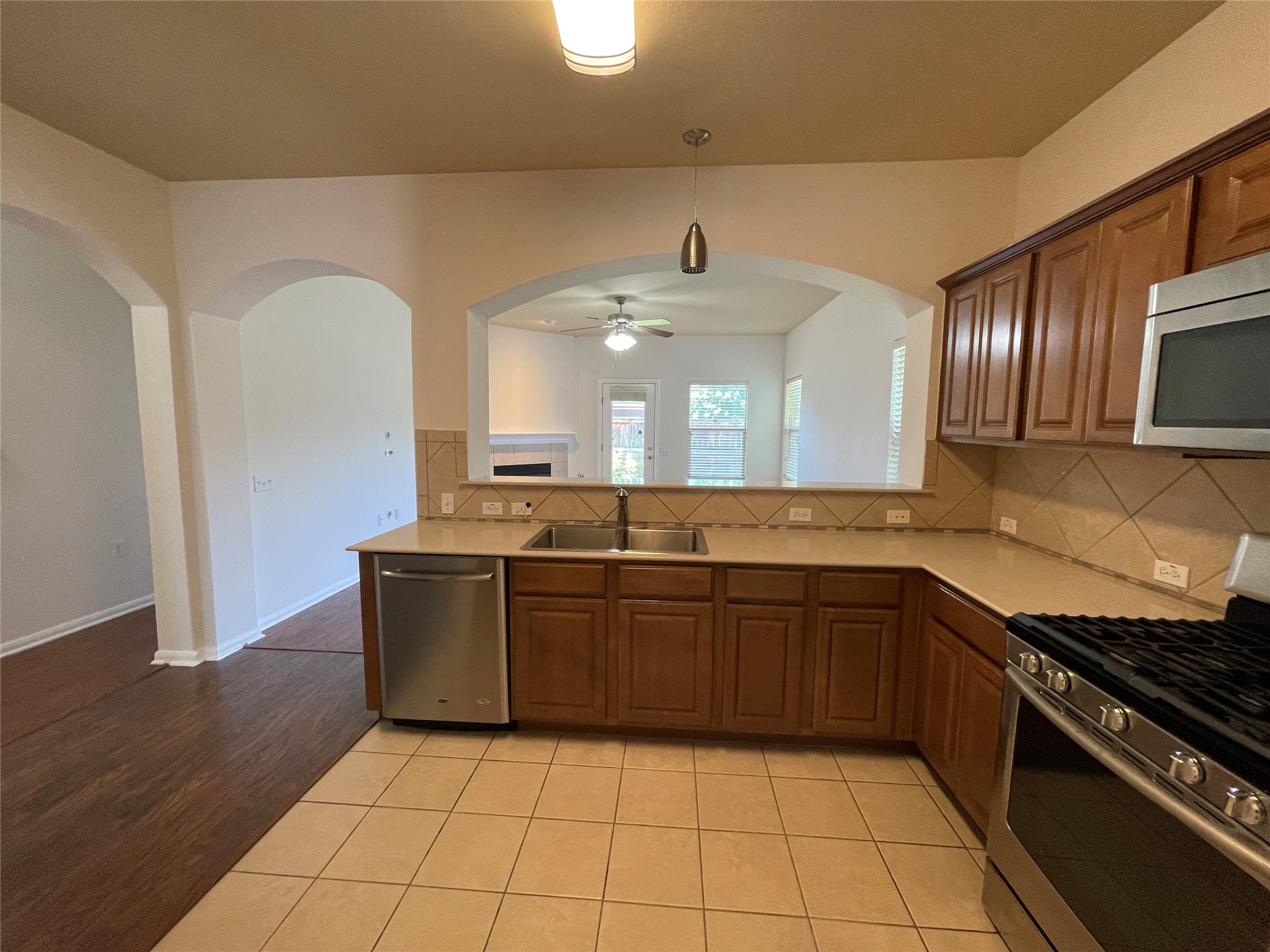 3517 Bronco Bend Loop Austin, TX 78744 - Photo 13 of 39 Kitchen featuring stainless steel appliances, light tile patterned floors, and wood finish cabinets