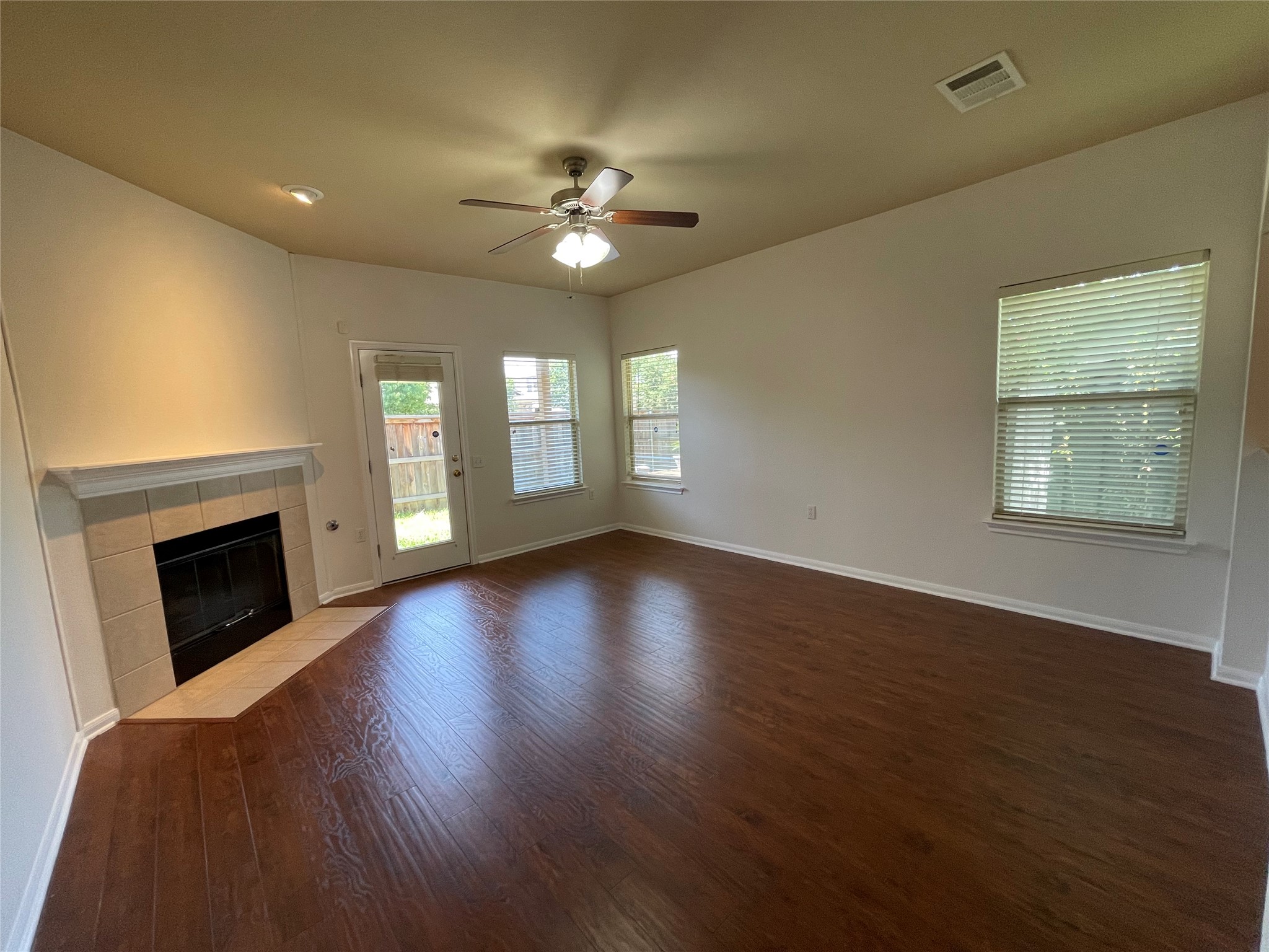 3517 Bronco Bend Loop Austin, TX 78744 - Photo 15 of 39 Unfurnished living room with a ceiling fan, a fireplace, and dark wood-style flooring