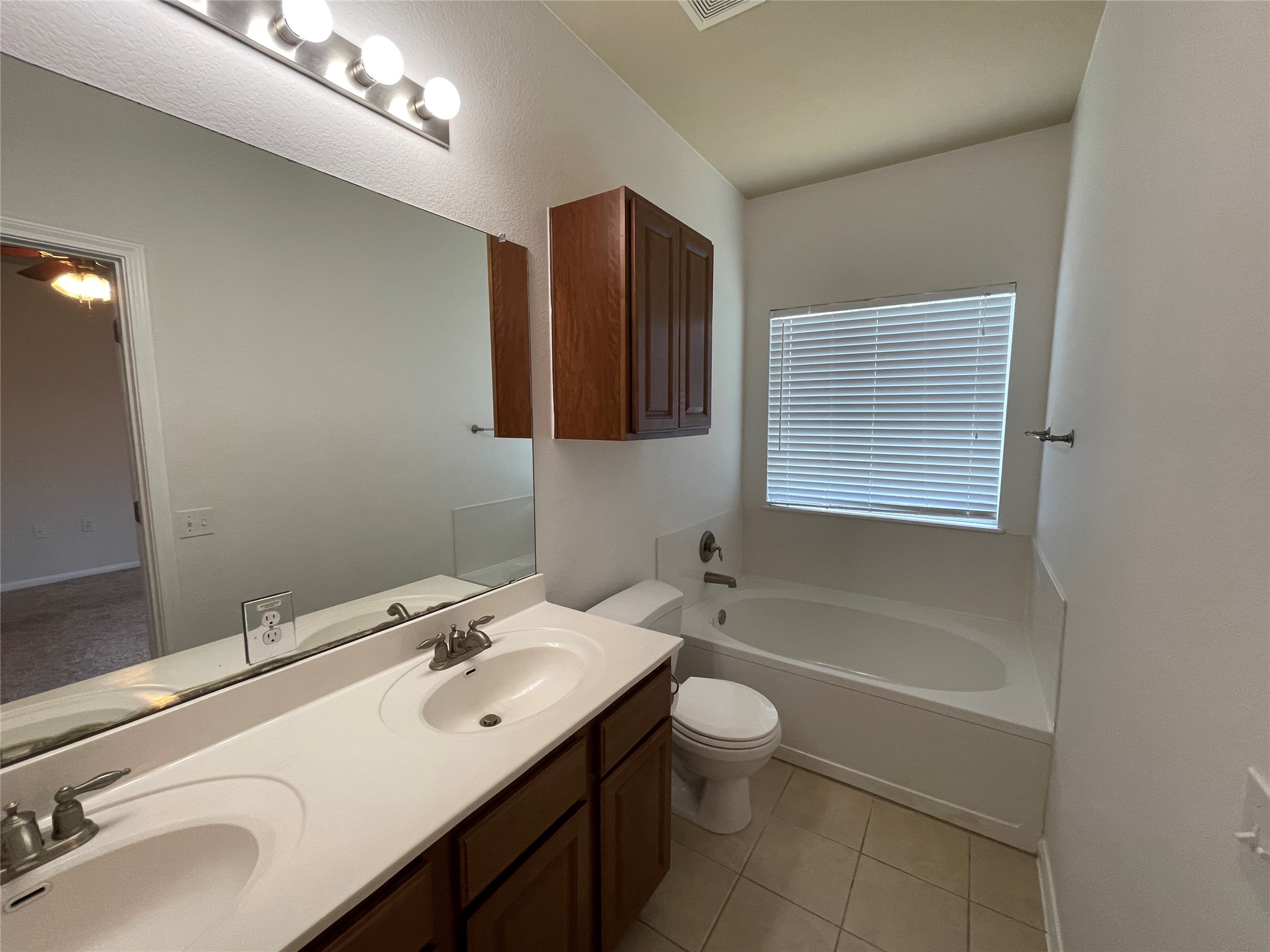 3517 Bronco Bend Loop Austin, TX 78744 - Photo 20 of 39 Bathroom featuring a garden tub, double vanity, and light tile patterned floors