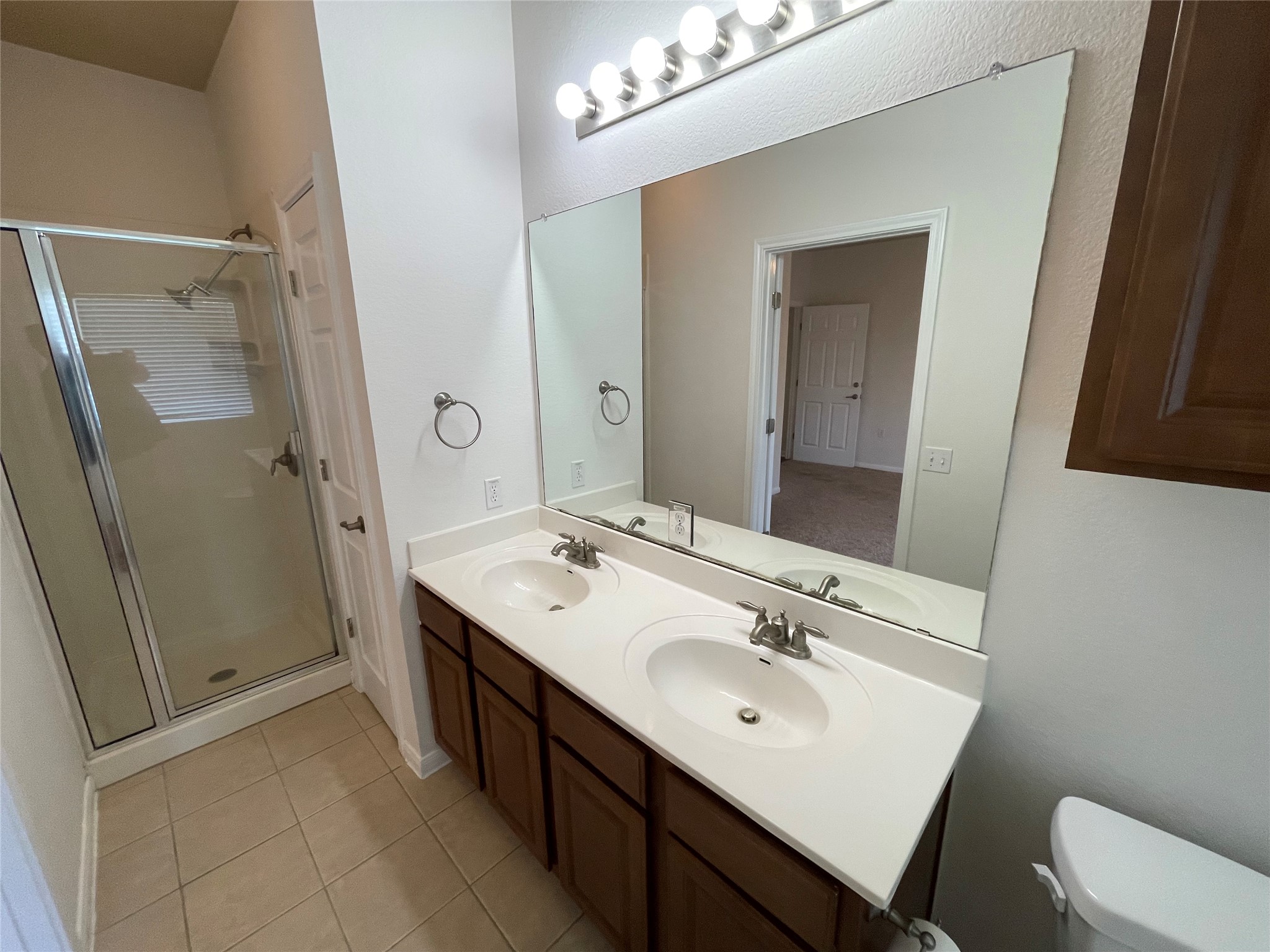 3517 Bronco Bend Loop Austin, TX 78744 - Photo 23 of 39 Full bathroom with double vanity, a shower stall, and light tile patterned floors