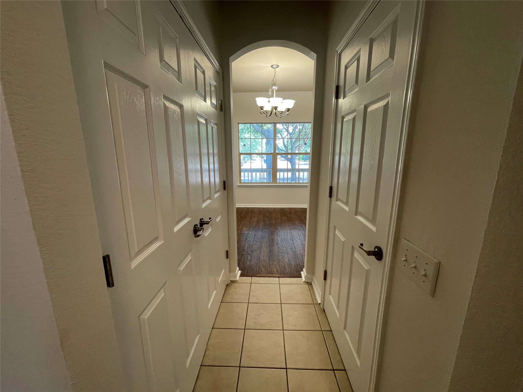 3517 Bronco Bend Loop Austin, TX 78744 - Photo 29 of 39 Hall featuring arched walkways, a chandelier, and light tile patterned floors
