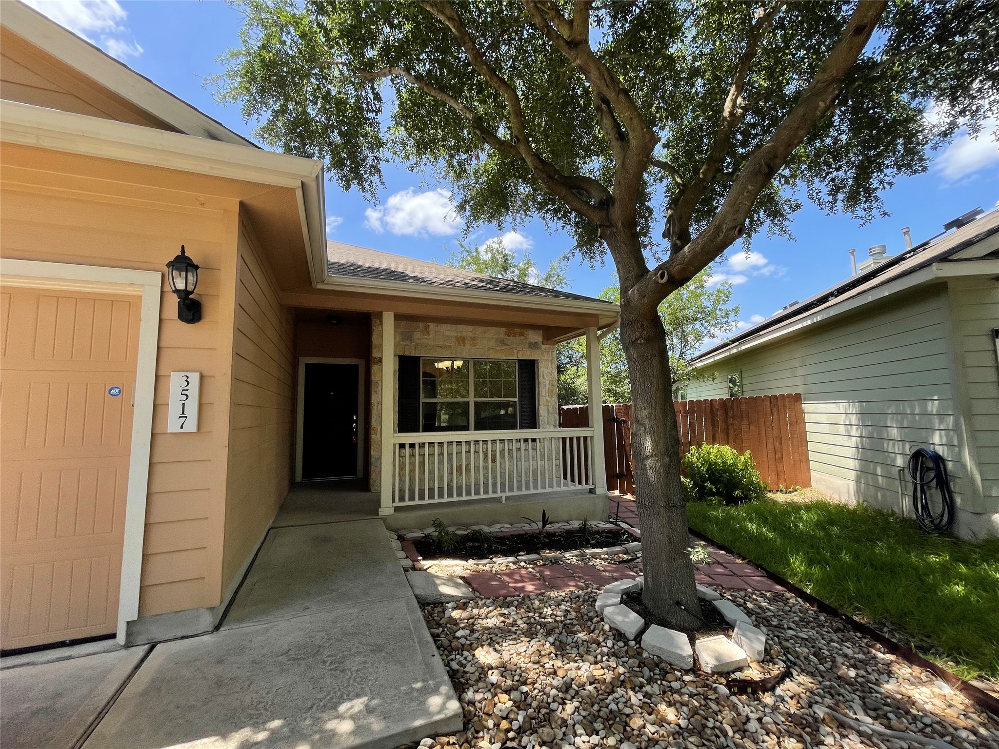 3517 Bronco Bend Loop Austin, TX 78744 - Photo 3 of 39 Property entrance with a porch, stone siding, and an attached garage