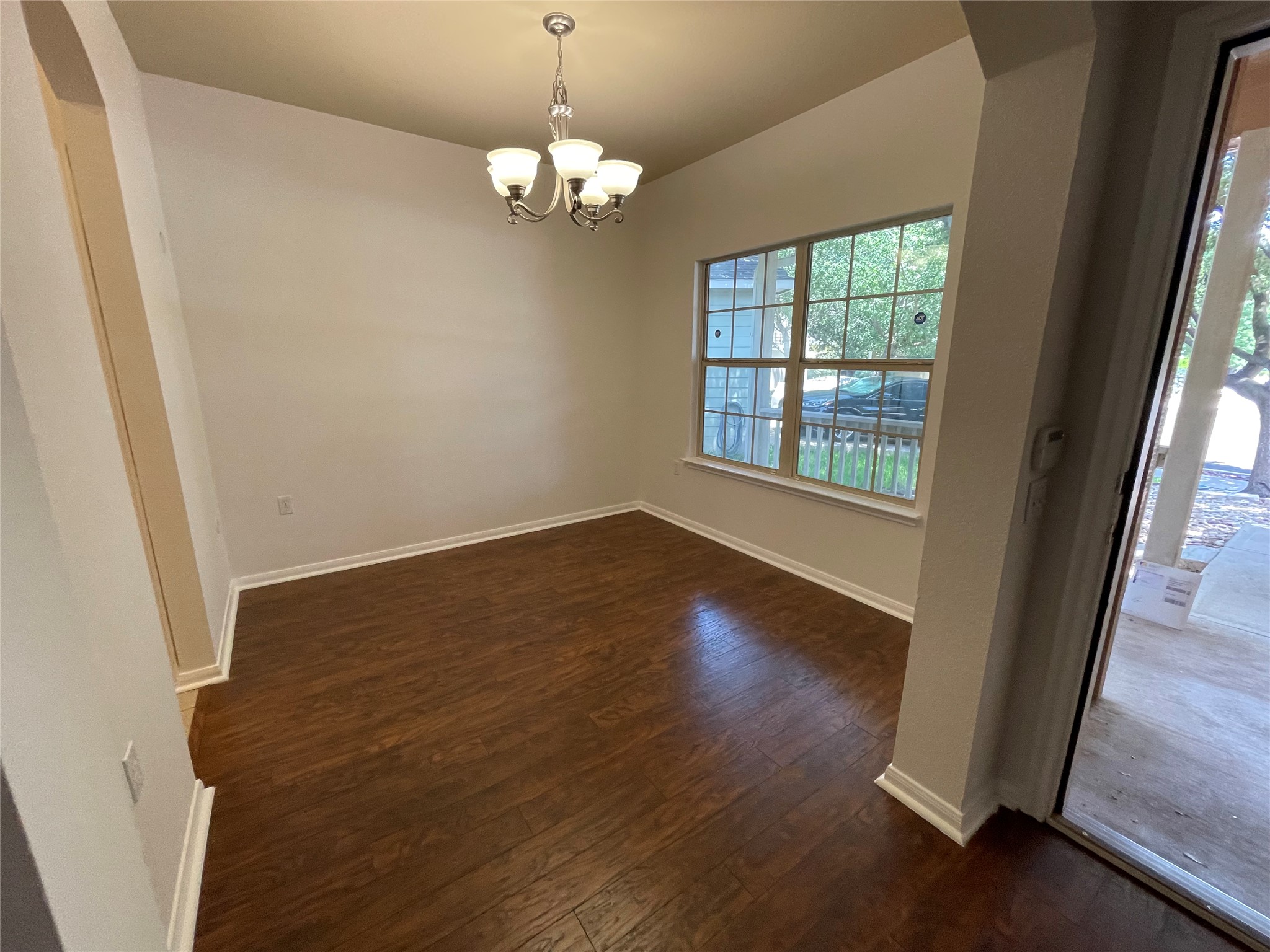 3517 Bronco Bend Loop Austin, TX 78744 - Photo 6 of 39 Spare room with dark wood-style floors, hanging lights, and arched walkways