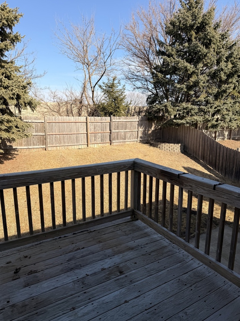 701 Davidson Drive, Unit B Minooka, IL 60447 - Photo 16 of 16 a balcony with wooden floor and fence
