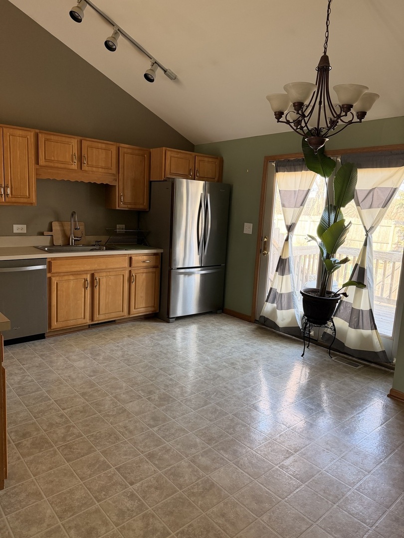 701 Davidson Drive, Unit B Minooka, IL 60447 - Photo 3 of 16 a kitchen with stainless steel appliances granite countertop a sink a stove and a refrigerator