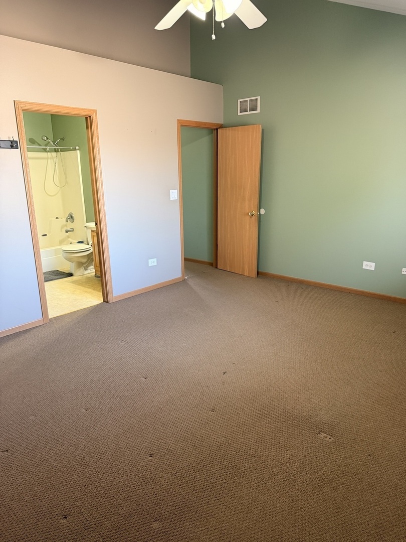 701 Davidson Drive, Unit B Minooka, IL 60447 - Photo 10 of 16 an empty room with a window and a chandelier fan