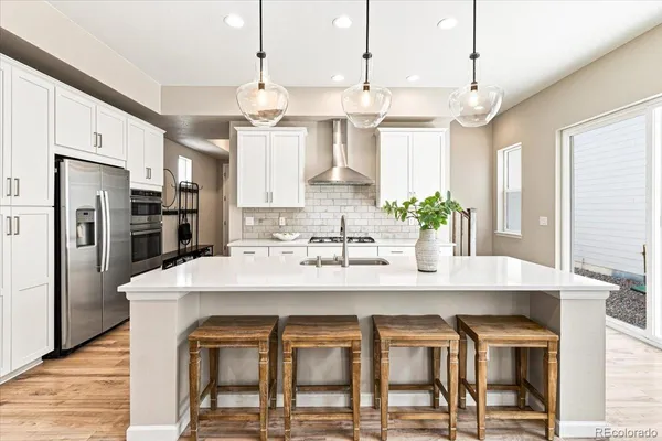 a kitchen with stainless steel appliances kitchen island granite countertop a table and chairs in it