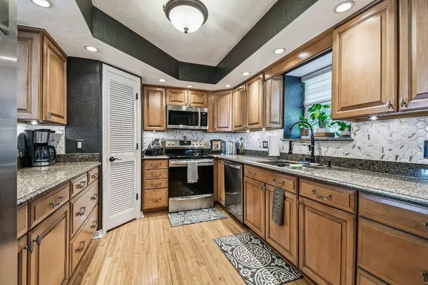a view of a hallway with wooden floor and living room