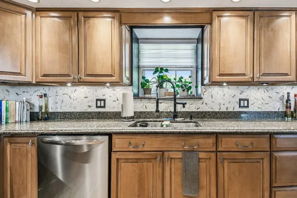 a bathroom with a granite countertop sink toilet and shower