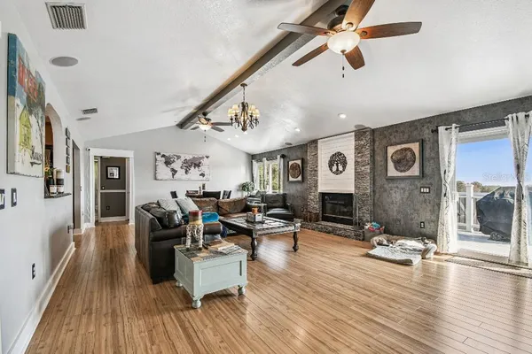 a living room with furniture a flat screen tv and a chandelier