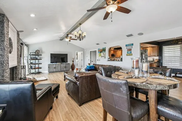 a kitchen with stainless steel appliances granite countertop a refrigerator a stove top oven a sink dishwasher and white cabinets with wooden floor