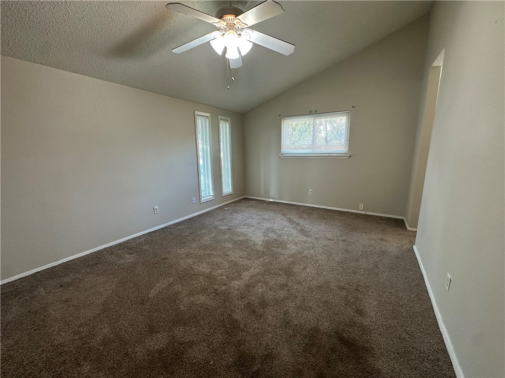 1506 Briar Street Portland, TX 78374 - Photo 28 of 40 an empty room with a chandelier fan and windows