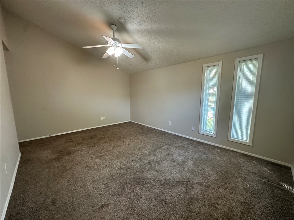 1506 Briar Street Portland, TX 78374 - Photo 29 of 40 an empty room with a chandelier fan and windows