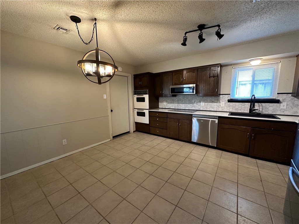1506 Briar Street Portland, TX 78374 - Photo 9 of 40 a kitchen with stainless steel appliances granite countertop a sink and cabinets