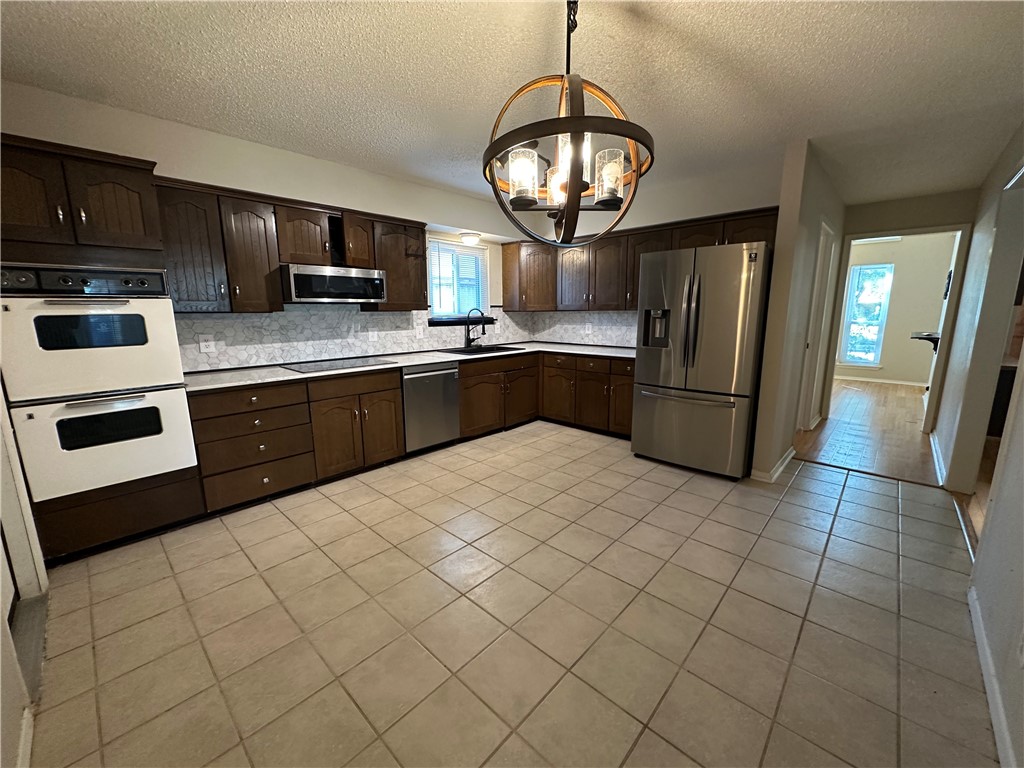 1506 Briar Street Portland, TX 78374 - Photo 10 of 40 a kitchen with stainless steel appliances granite countertop a refrigerator and a stove top oven
