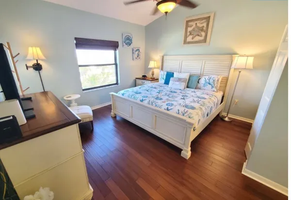 a bedroom with a bed window and wooden floor