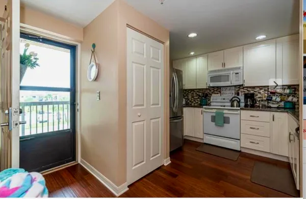 a kitchen with white cabinets and window