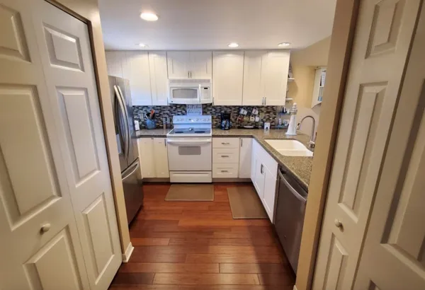 a kitchen with stainless steel appliances a refrigerator a sink and cabinets