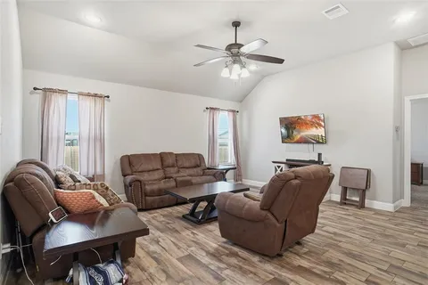 a living room with furniture and a wooden floor