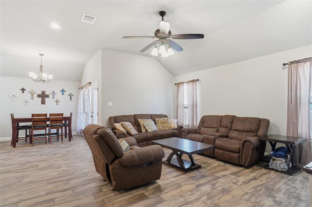 206 McKittrick Lane Godley, TX 76044 - Photo 14 of 28 Living room with vaulted ceiling, light wood-style floors, a chandelier, and a ceiling fan
