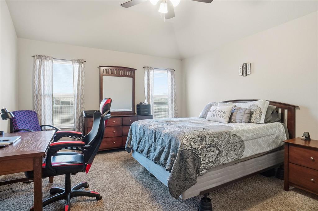 206 McKittrick Lane Godley, TX 76044 - Photo 16 of 28 Carpeted bedroom featuring an office area, vaulted ceiling, and ceiling fan