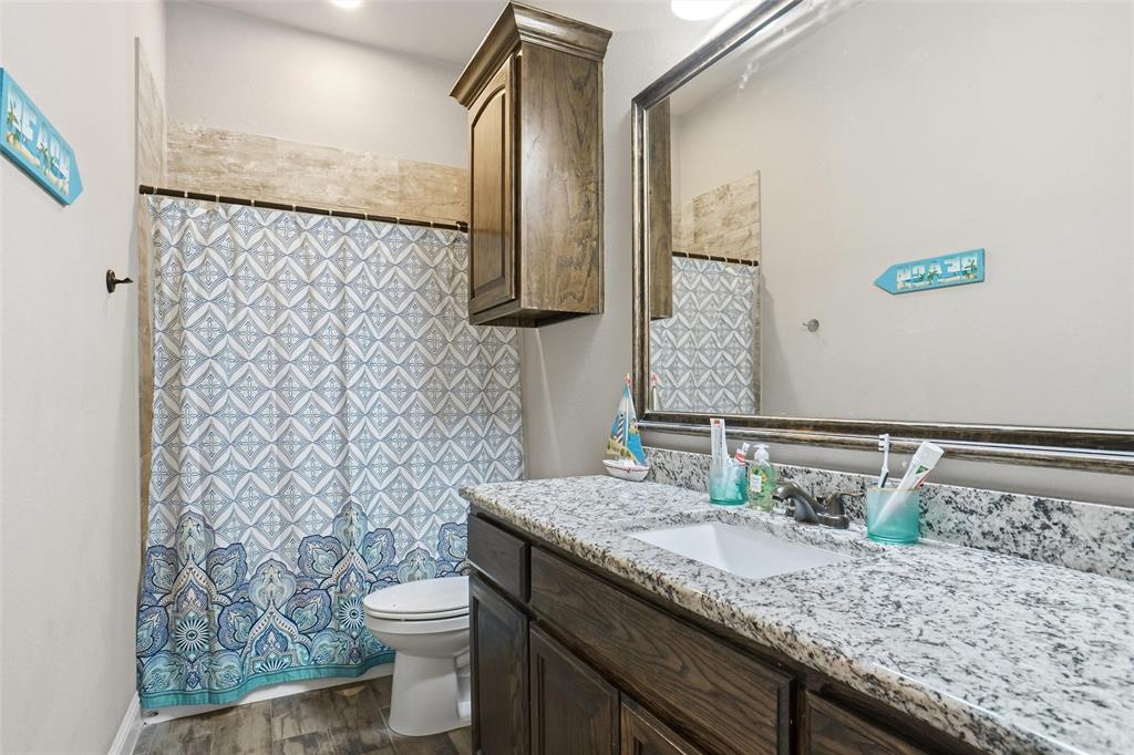 206 McKittrick Lane Godley, TX 76044 - Photo 23 of 28 Bathroom with curtained shower, vanity, and dark wood finished floors