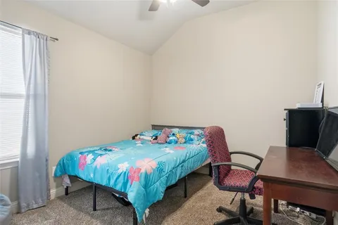 a bedroom with a bed a chair and a potted plant