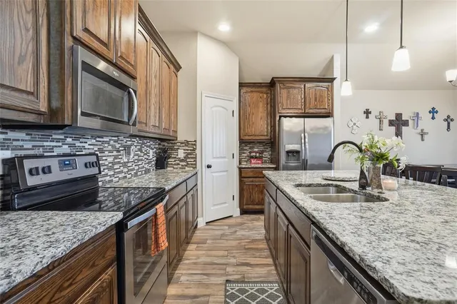 a kitchen with stainless steel appliances granite countertop a sink stove and cabinets