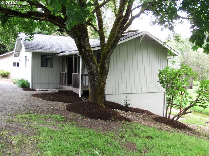 1940 Northeast 3rd Loop Camas, WA 98607 - Photo 20 of 22 a white house covered with tall trees