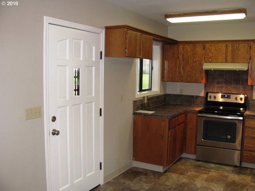 1940 Northeast 3rd Loop Camas, WA 98607 - Photo 6 of 22 a kitchen with granite countertop a stove sink and cabinets