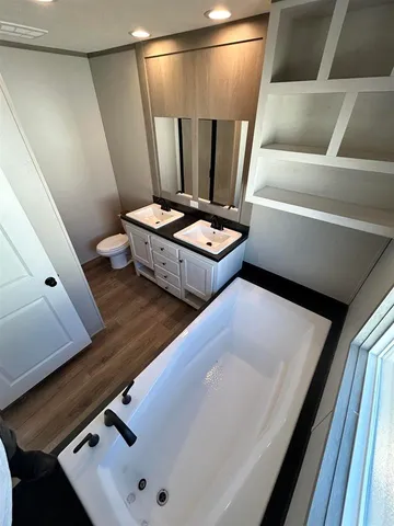 a bathroom with a double vanity sink a toilet and a mirror
