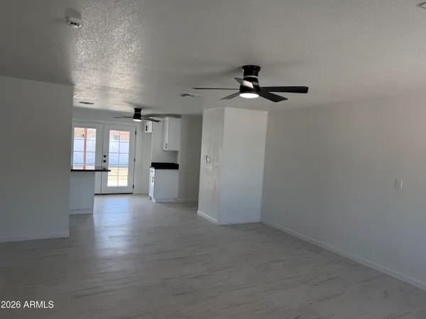 a view of a livingroom with a ceiling fan wooden floor and windows