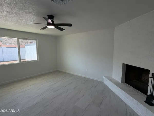 an empty room with a fireplace and windows