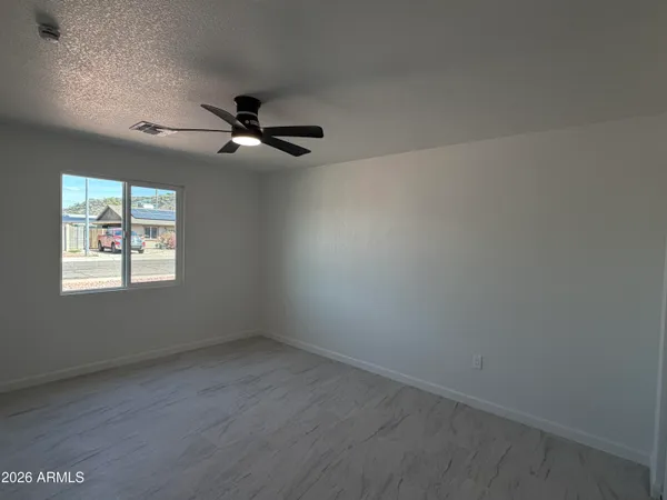 an empty room with a window and ceiling fan