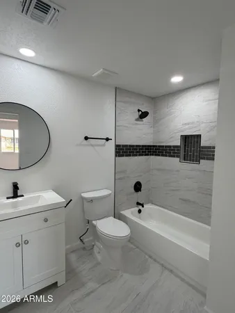a bathroom with a bathtub shower sink mirror and toilet