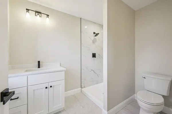 a bathroom with a sink a toilet and shower