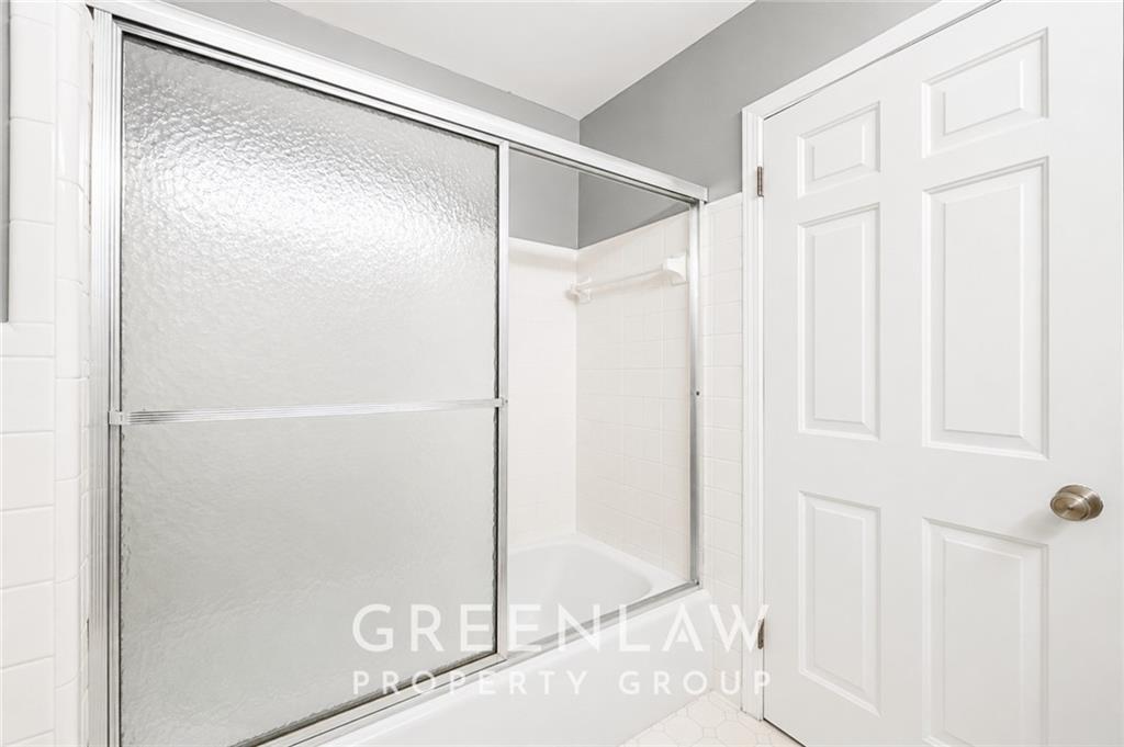 3605 Flat Shoals Road Atlanta, GA 30349 - Photo 24 of 35 a bathroom with a glass shower door