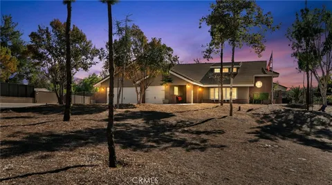 a large white kitchen with granite countertop a stove top oven a sink a dining table and chairs