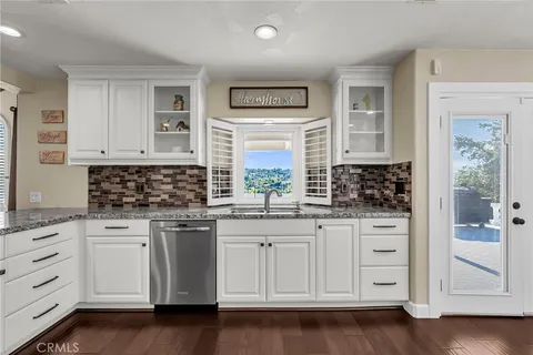 a kitchen with stainless steel appliances wooden floors and wooden cabinets
